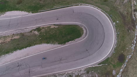 cyclist on a mountain pass in the dolomites, italy, from a drone