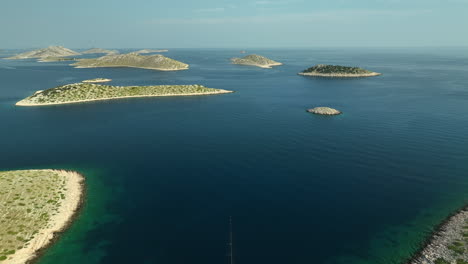 aerial backwards drone panning shot of a yacht anchored between islands