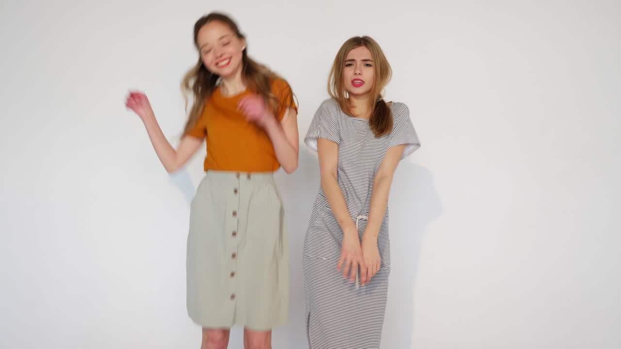 두 친구가 스튜디오에서 춤을 춘다.