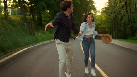 Happy-man-and-woman-having-fun-outdoors.-Happy-couple-running-on-road-in-park