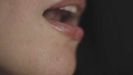 Close up portrait of pretty brunette woman with natural make up seductively licking ripe juicy piece of dragon fruit or pitaya