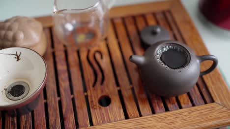 tea ceremony on a portable table. hot water is poured into a small teapot with tea leaves