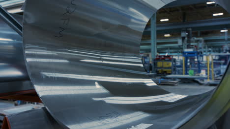 dolly shot inside factory, close up metal rolls