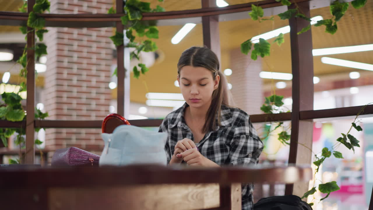 joven aplica cuidadosamente polvo líquido en la cara mientras está sentada en una mesa de madera con artículos esenciales de maquillaje, expresión enfocada mientras mezcla la fundación con precisión en un entorno interior acogedor y bien iluminado