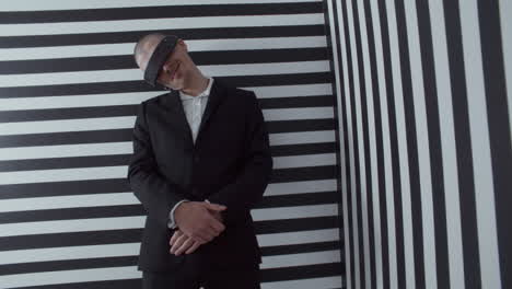 man wearing vr headset and a black suit in a striped room