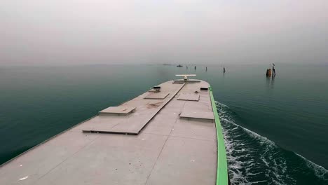 Aerial-pov-of-ferry-boat-roof-navigating-in-Venetian-lagoon,-Venice-in-Italy