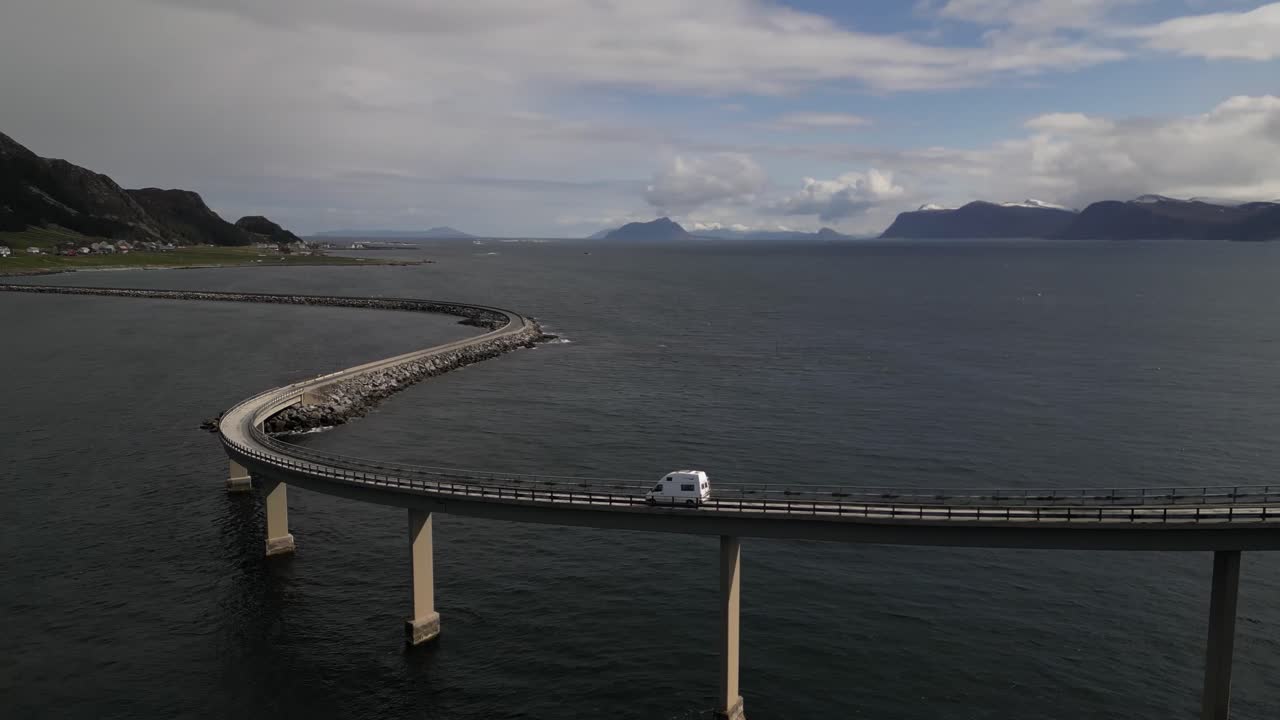 Drone view of a white car driving above Atlantic Road. Atlanterhavsveien National Tourist Route. Road on the Sea in Norway.
