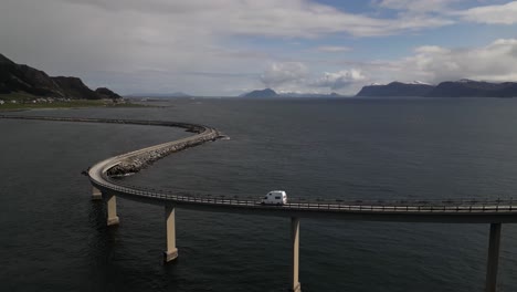 drone view of a white car driving above atlantic road. atlanterhavsveien national tourist route. road on the sea in norway.