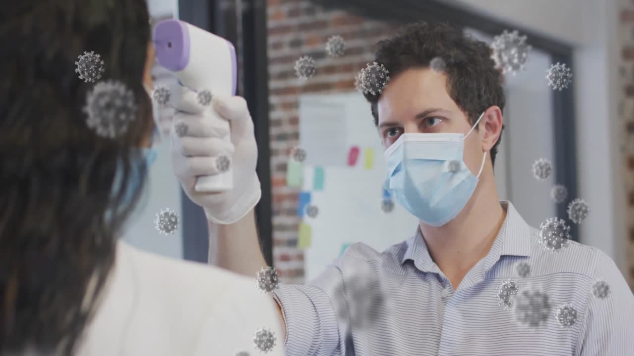 Animation of covid 19 cells over man in face mask measuring woman's temperature