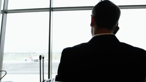 businessman talking on mobile phone at airport