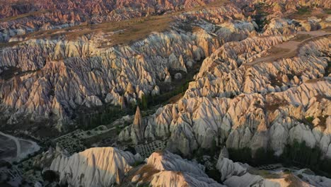 cappadocia landscape with tuff stone formations after sunrise, tilt down aerial