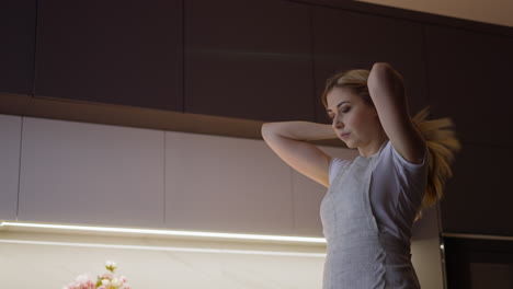 mujer ajusta el cabello lista para cocinar la cena en una cocina espaciosa