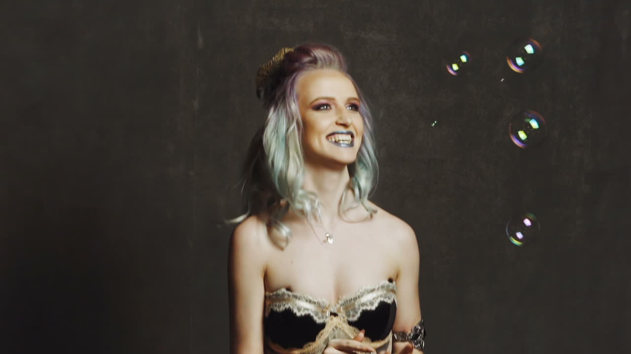 Woman with bubble. Young girl having fun with bubbles in studio
