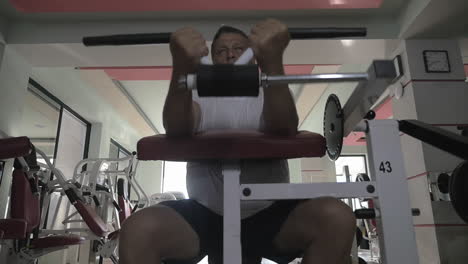 senior man doing exercise on training machine in gym