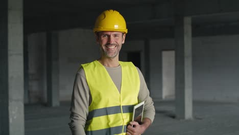 portrait of caucasian engineer holding digital tablet while standing on construction site