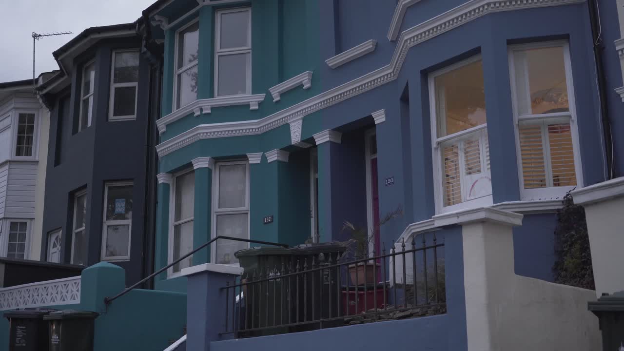 hermosa vista cercana de las casas delanteras pintadas en diferentes colores en una calle de brighton, inglaterra, reino unido durante el día ventoso