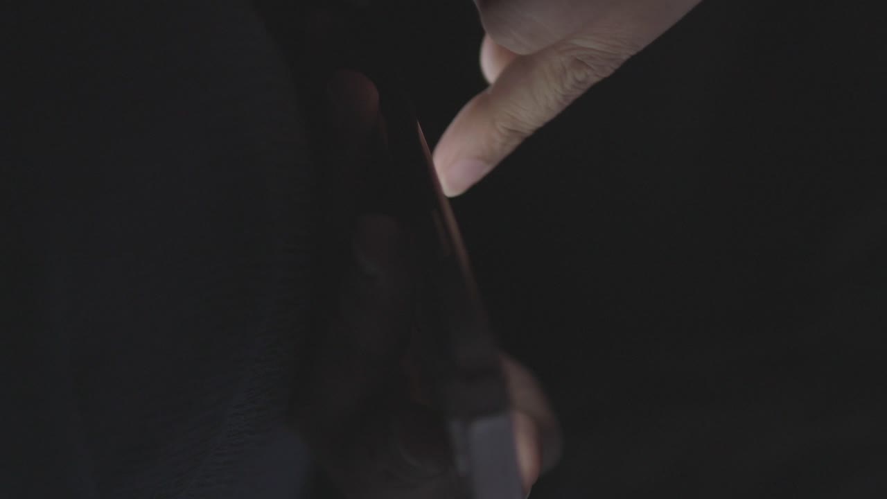 persona que utiliza un teléfono inteligente por la noche