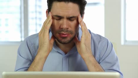 Stressed-businessman-looking-at-laptop