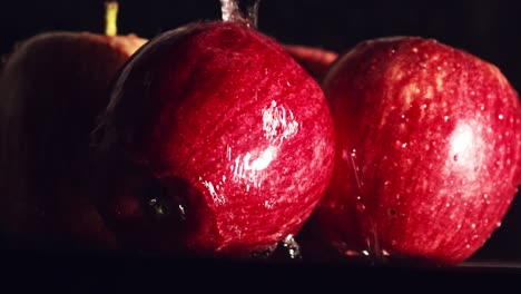 water droplets splashing on red apples in slow motion