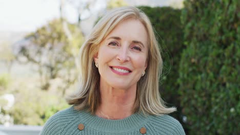 Video-portrait-of-happy-senior-caucasian-woman-with-blonde-hair-smiling-in-garden