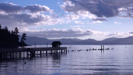 a beautiful sunset behind a resort and silhouetted pier at glenbrook lake tahoe nevada