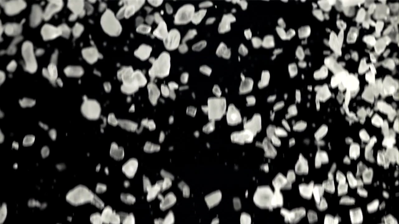 White Salt Crystals Falling in Slow Motion on Black Background