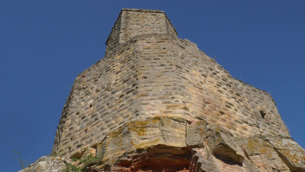 Vista en contrapicado de la histórica torre de piedra del Castillo de Gräfenstein contra un cielo azul