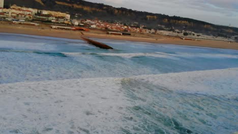 Disparo-De-Un-Dron-Volando-Sobre-El-Agua-De-Espuma-Blanca,-Cerca-De-La-Playa.