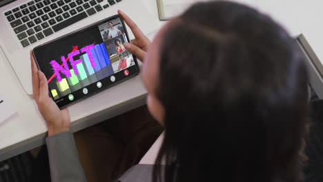 mujer de negocios biracial que usa una tableta para videollamadas con diversos colegas de negocios