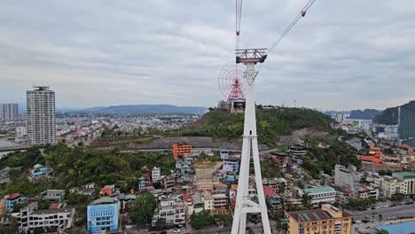 panoramic cityscape of ha long city from queen cable car cabin with urban buildings sprawling across green hillsides below