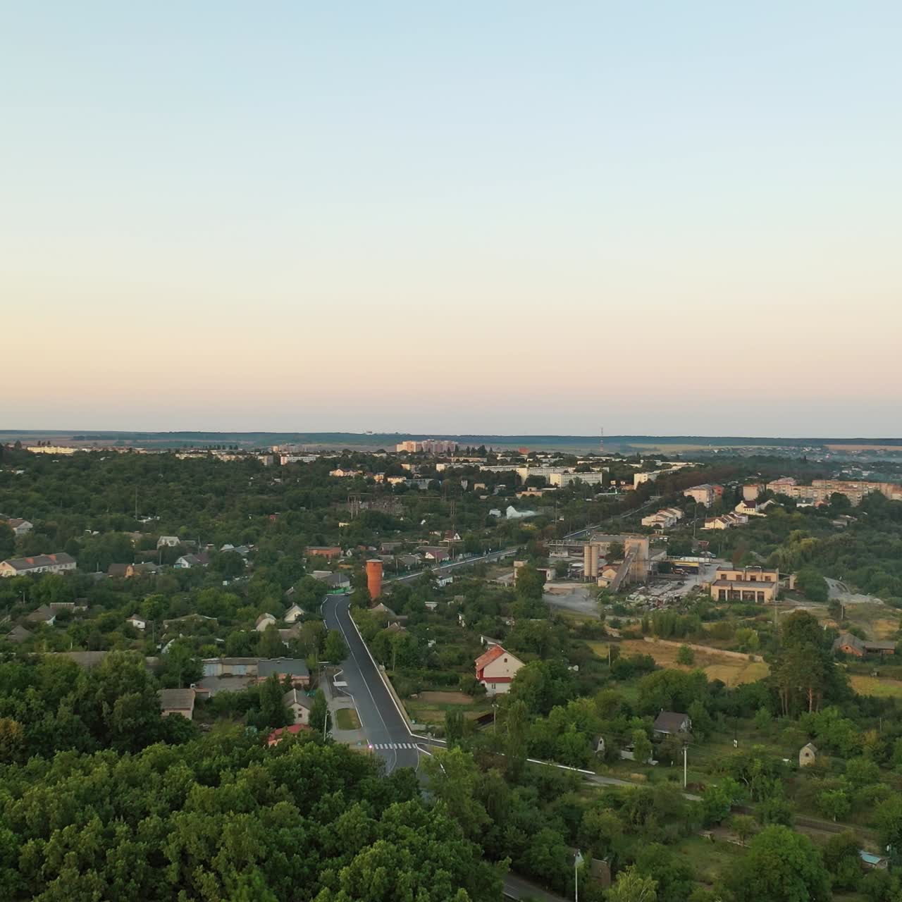 Aerial footage of small town in summertime. Beautiful landscape of small town or village with houses and green trees. Aerial view.