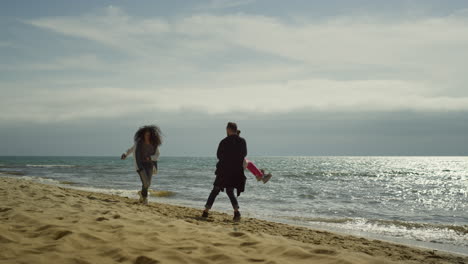 parents child playing beach by seascape. cheerful people having fun on nature.