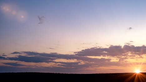 beautiful evening sunset, time lapse, movement of clouds of a different level against the setting sun, loop.