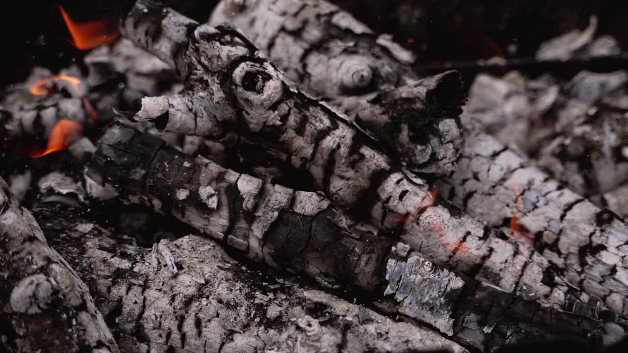 Ready embers of wood for barbecue. Glowing charcoals. Hot embers of burning wood log fire. Firewood burning on grill. Close-up.