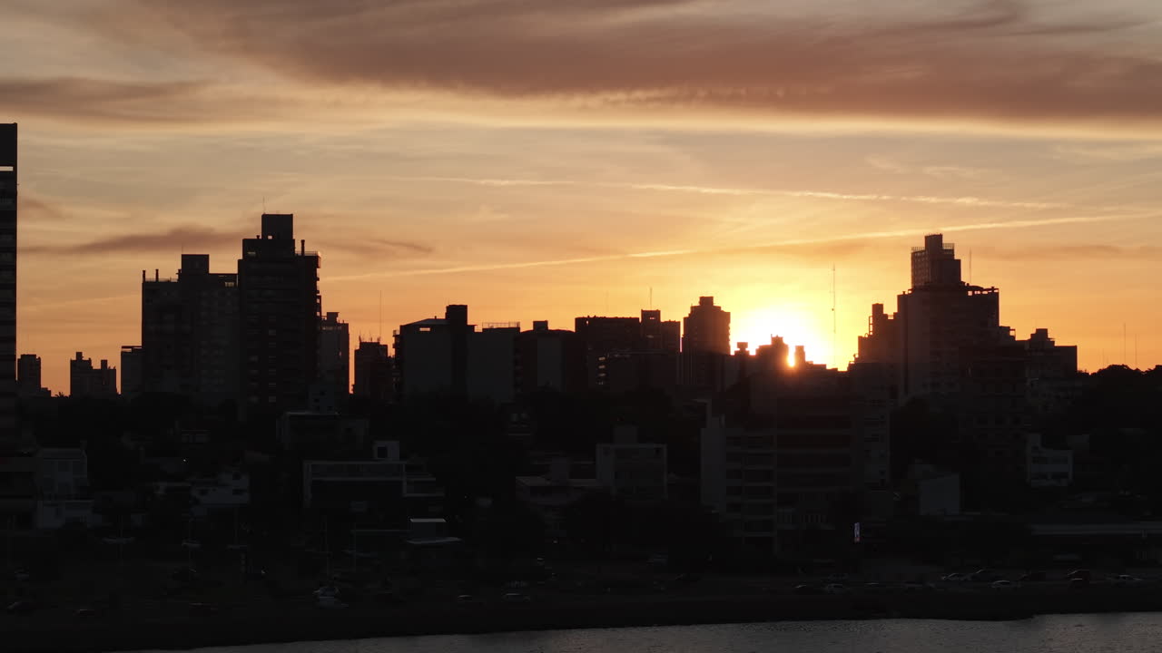 Vibrante atardecer con el claro horizonte de Posadas y ricos reflejos sobre aguas ondulantes.