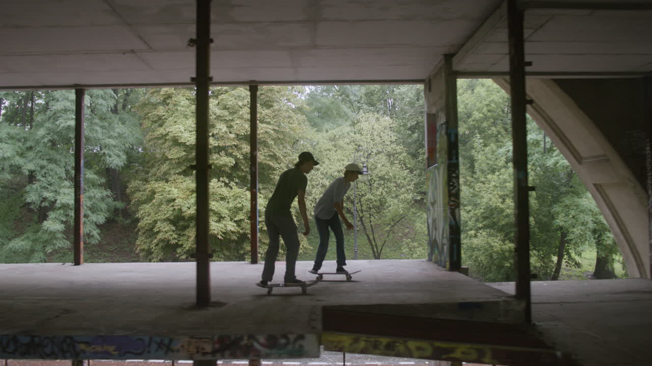chicos caucásicos patinando en un edificio en ruinas.