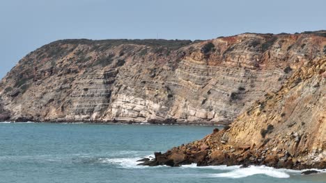 Aerial-panning-shot-of-rugged-cliffs-along-the-coast-of-the-Atlantic-Ocean