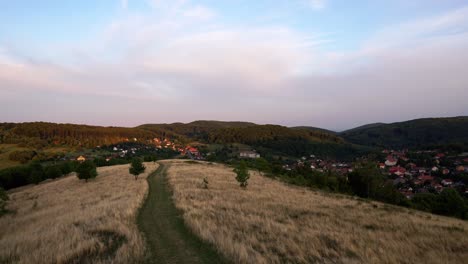 timelapse video from hungary, bükkszentkereszt lookout tower, dirt road leads to the mountains through the village at sunset