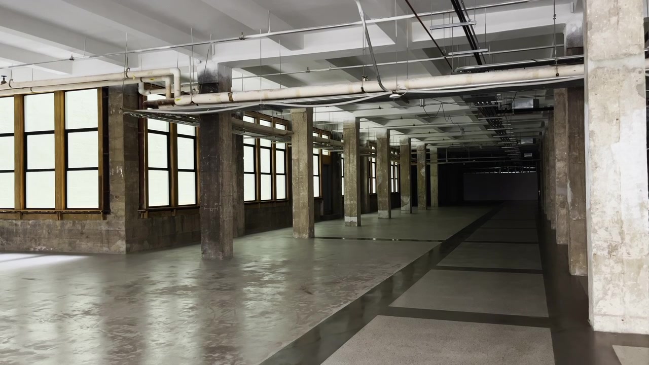 Static wide view shows an empty industrial space with columns and exposed pipes