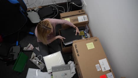 Young-woman-packing-stuff-for-moving-out-of-the-apartment-top-down-shot