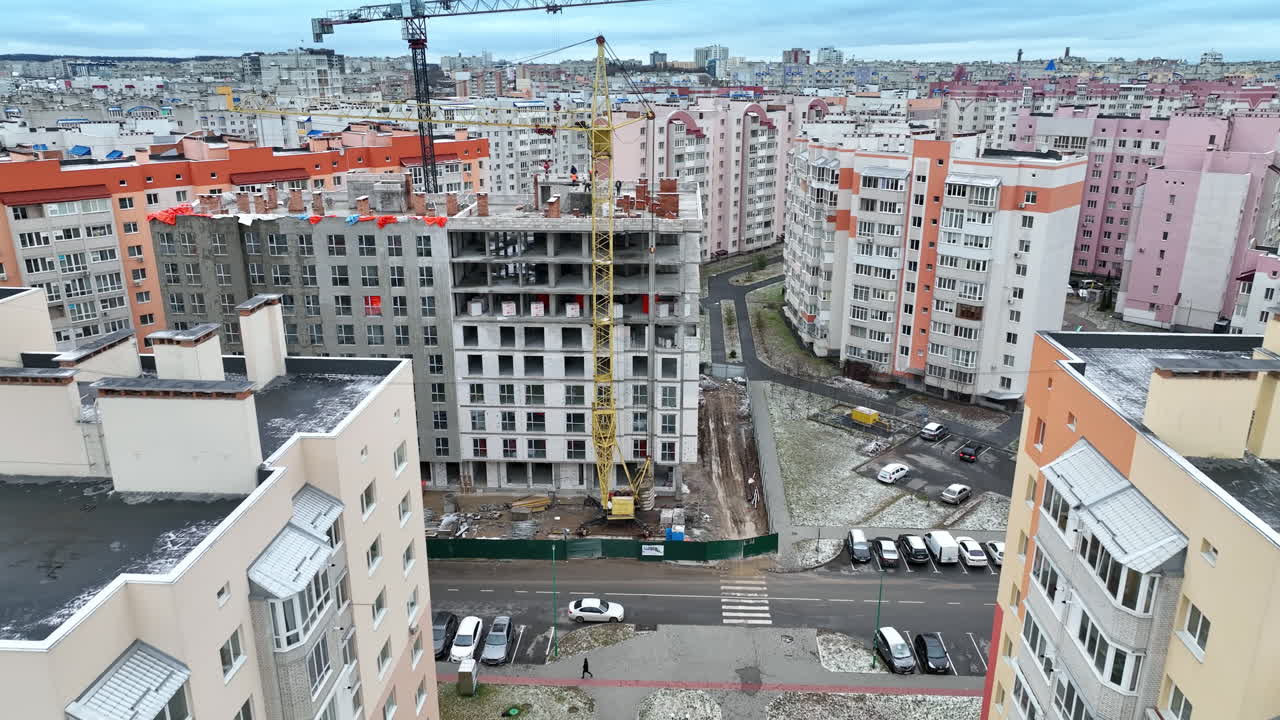 The construction of new high block of flats in the residential area. Densely built new neighborhood with light apartment blocks. Aerial view.