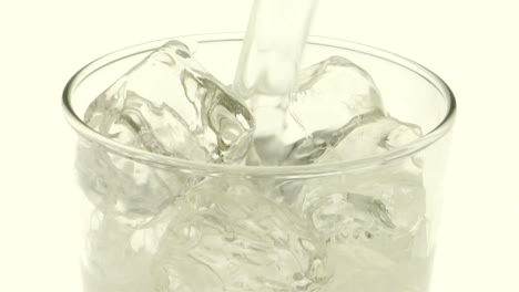 Se-Vierte-Líquido-Transparente-Con-Gas-Sobre-Hielo-En-Un-Vaso.