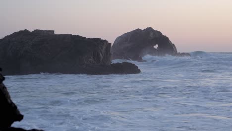 sunset and waves crashing on rocks
