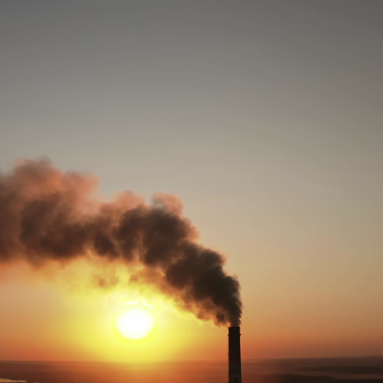 Toxic dark smoke filling the evening sky. Pipes with chemical emissions going into the air against the sunset. Ecological problems in the atmosphere