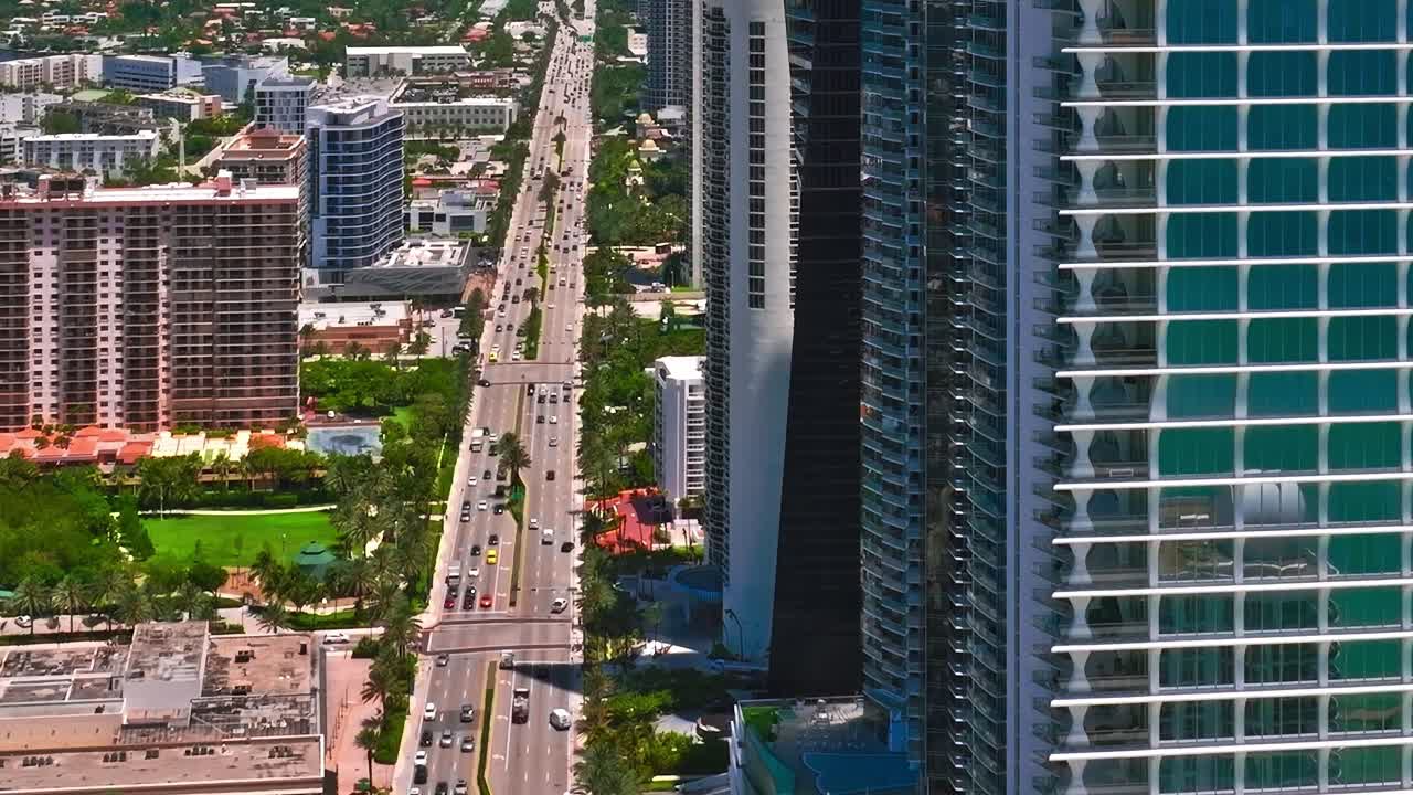 Vista aérea de Miami mostra edifícios altos e área de praia ao fundo.