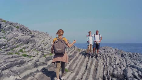 young woman taking photo with mobile to her parents through flysch rock