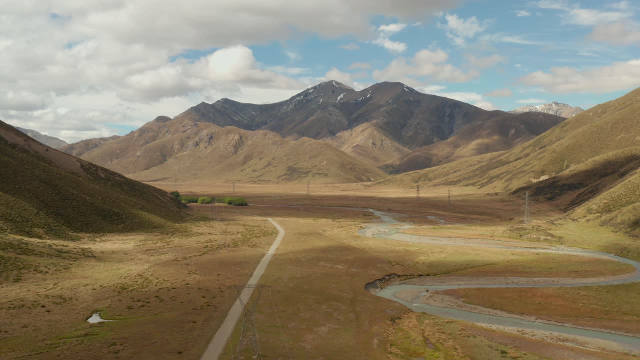 вид с беспилотника на долину в новой зеландии с извилистой рекой и высоковольтными вышками