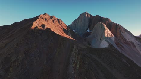 convict lake canyon trail glacier sierra nevada range rugged mountainside layers mammoth lakes drone aerial california autumn fall late afternoon shaded rugged valley peaks clear skies forward pan up