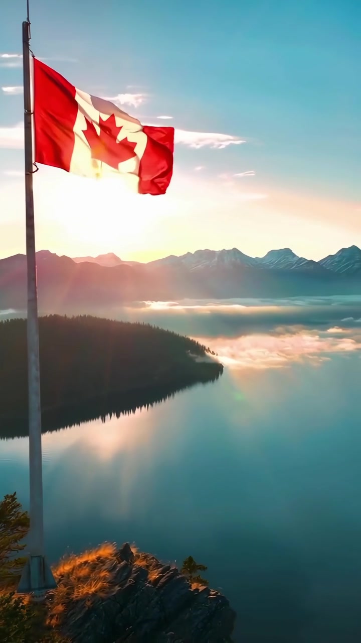 Bandiera canadese che sventola sopra un maestoso lago di montagna all'alba