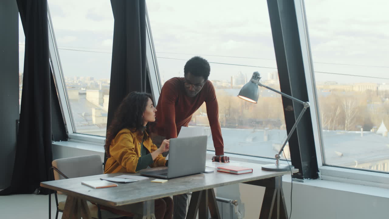 Diverse Coworkers Discussing Document in Modern Office